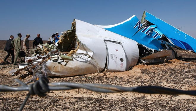 A handout picture provided by the Russian Emergency Ministry press service on Nov. 2, 2015, shows Russian Emergency Situations Minister Vladimir Puchkov (fourth from left4) and unidentified officials near a piece of wreckage of Russian MetroJet Airbus A321 at the site of the crash in Sinai, Egypt.
