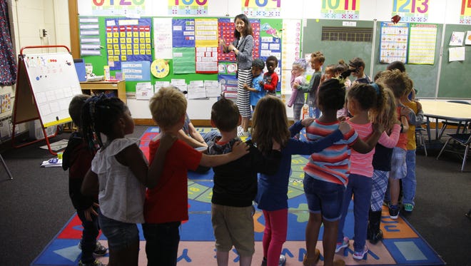 Jing Xia teaches students in her kindergarten class with a fun exercise, Monday, Oct. 2, 2017, at Post Oak Academy in Lansing, Mich.
