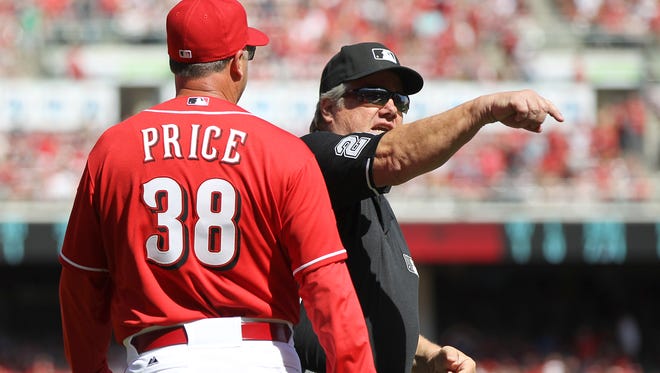 Cincinnati Reds manager Bryan Price, left, is ejected by umpire Joe West in the eighth inning during the game against the St. Louis Cardinals, Sunday, April 12, 2015, at Great American Ball Park.