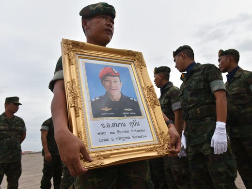 A Royal Thai Navy soldier carries a portrait of Saman