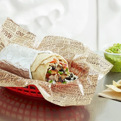 A Chipotle burrito with chips and guacamole.