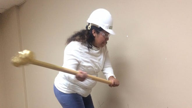 Rosa Ramirez swings a sledgehammer Friday, Dec. 16, 2016, as she puts a hole in a wall that is being torn down in the basement of the Madison-Monroe Building for the renovation of classroom space for Literacy Green Bay. Ramirez, a Green Bay resident, is an adult learner at the downtown agency. The $189,000 renovation project, which is funded by private and corporate donors, is expected to be finished at the end of January.