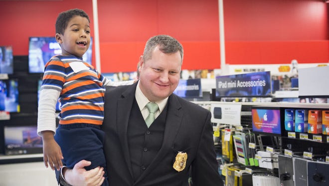 Four-year-old Izayah Bowie, of West York, gets a lift from West York Borough Police Chief Justin Seibel while shopping. Children shop with local law enforcement officers at Target in West Manchester Township while participating in the Shop with a Cop program, Tuesday, December 8, 2015.
