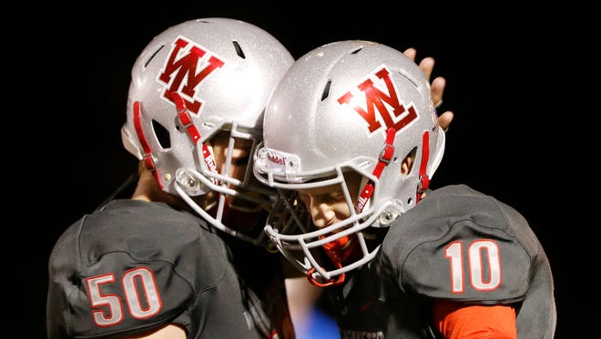 West Lafayette quarterback Luke Touloukian, right, is congratulated by August Schott after his rushing touchdown at 6:40 in the third quarter against Twin Lakes Friday, October 6, 2017, at Gordon Straley Field in West Lafayette. Touloukian’s score put the Red Devils up 49-0 over Twin Lakes. West Lafayette pounded Twin Lakes 70-0.