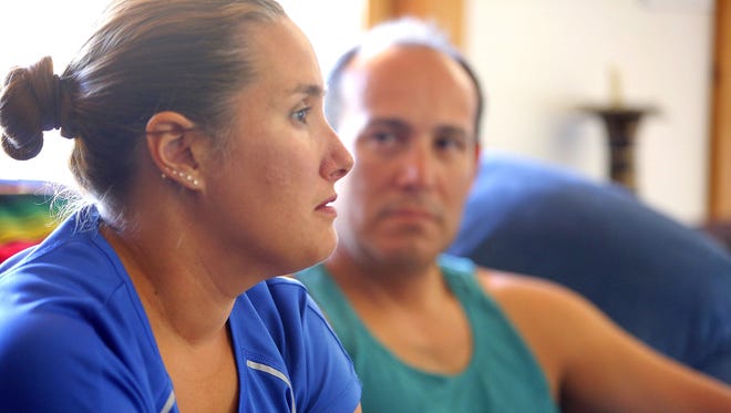 Sergio Celis (right) watches as his wife Becky discusses the case of her missing daughter Isabel at her home in Tucson on April 14, 2014.