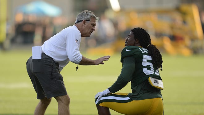 Green Bay Packers assistant special teams coach Ron Zook talks with Jamari Lattimore during training camp practice at Ray Nitschke Field last August.