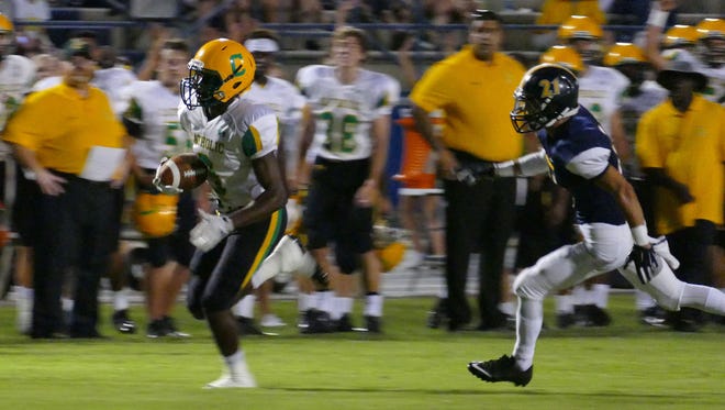 Catholic's Simeon Smiley runs past a Gulf Breeze defender during action this past season. Smiley was named a first-team Class 3A all-state player by the sports writers of Florida.