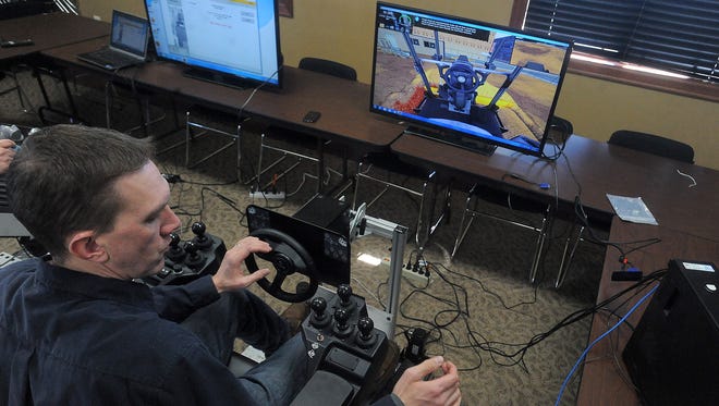 ACG's Justin Ehlers uses a Motor Grader simulator during a training at Home Builders Association of the Sioux Empire on Feb. 12, 2016.