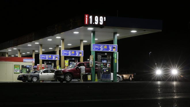 Motorists purchase gas at a station in Texas that dropped the unleaded fuel price to $1.99 per gallon on Aug. 26.