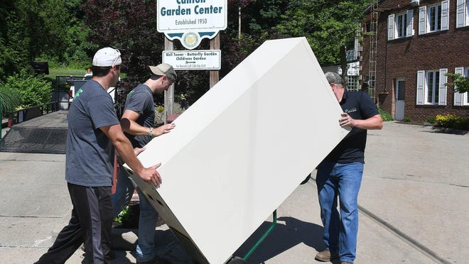 Zach Courter, Trent Davis and Gregg Horrisberger move a large filing cabinet Thursday to the Canton Parks and Recreation Department's new offices on the second floor of the Canton Garden Center.