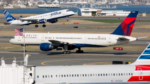 JetBlue, Delta and American airlines planes are seen at Boston's Logan International Airport on April 13, 2015.