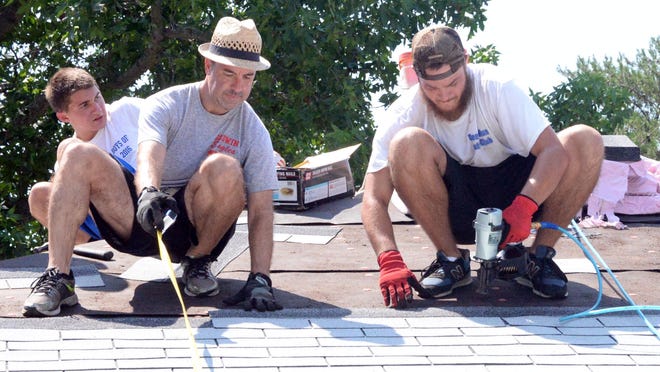 
Tim Wight (foreground, left), and Cary Wimbish, volunteers with Gayton Baptist Church and Toolbox Ministries of Richmond, Va., work on the roof of a Millville house on Wednesday. See video at www.thedailyjournal.com/video. 
