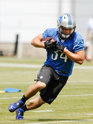 Lions running back Zach Zenner takes the ball upfield during drills.