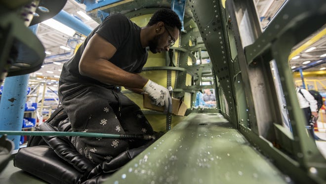 Orlando Dean, a defense contractor assembly mechanic, looks over a portion of an F-15E Strike Eagle at a defense contractor's factory in St. Louis, Aug. 3, 2017. During the visit, military members were given the opportunity to meet those who create the products they use on a daily basis.