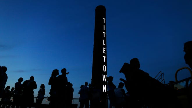 People are silhouetted against a dusk sky as they hang out on the new Roof Tap patio at Titletown Brewing Company's Tap Room in downtown Green Bay on Wednesday, July 13, 2016.