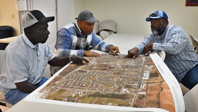 New Jerusalem Baptist Church deacons Billy Land, left, Johnnie Williams and Alonzo Nelson, right, plan out the locations of dumpsters and resources for Operation Fresh Start.