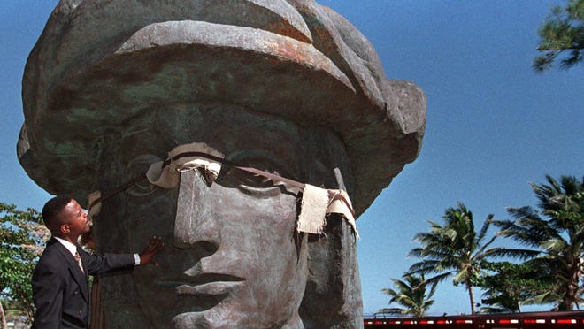 FILE - Victor Andino of the Catano mayor's office, examines the head of Christopher Columbus as it sits in a park along with 2,000 other pieces that will make up this 660-ton statue  in Catano, Puerto Rico Wednesday, Jan. 27, 1999.   Residents in a nearby seaside neighborhood where the statue is to be erected  are angry over plans to demolish their homes to make way for this statue Christopher Columbus that rivals the Statue of Liberty in size.  The statue was a gift to Puerto Rico by Russian sculptor Zurab Tsereteli.