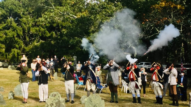 The Yarmouth Minutemen fire a regulation musket volley at the Marstons Mills Cemetery last Saturday to honor 12 veterans of the Revolutionary War (1776-1783) who are buried in gravesites that have been newly cleaned and restored.