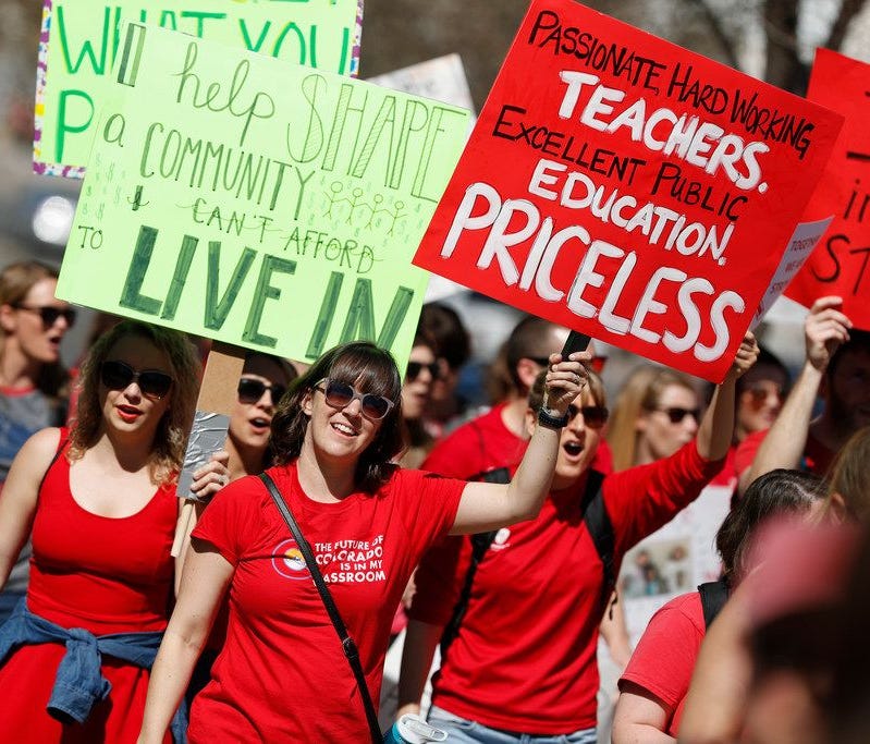 Teachers march during a rally, Friday, April 27, 2018, in Denver. More than 10,000 teachers from more than 20 districts scattered across Colorado are demonstrating as part of a burgeoning teacher uprising that is demanding more tax dollars be spent i