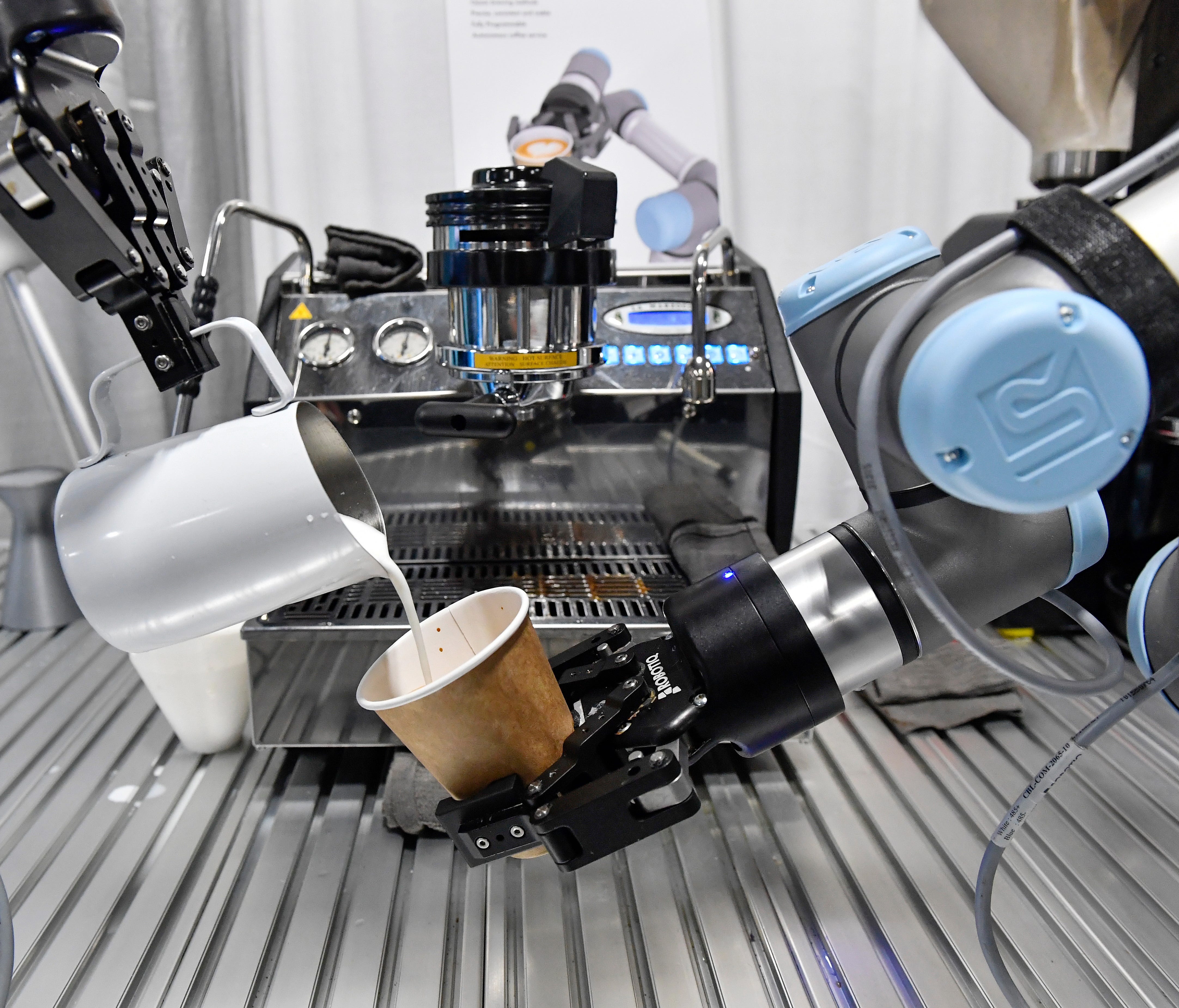 A robot barista makes a cup of coffee during the opening day of CES. The robot barista is a prototype from Bubble Lab from  Beijing.  