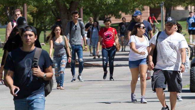 New Mexico State University students walk on campus in September 2017. Too few low-income New Mexicans are enrolled in higher education, a new report says.