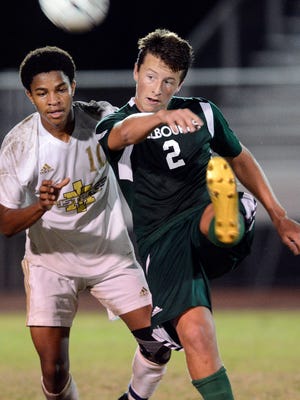 Ben Baldwin of Melbourne directs the ball away from Steven Saunders of Merritt Island. Both teams are No. 2 seeds in district tournaments this week.