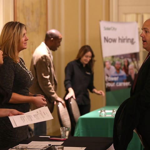 A job seeker (R) meets with recruiters during a...