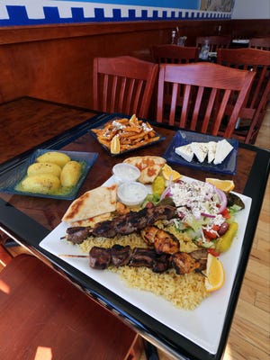 A selection of food at The Greek Spot on McLean Avenue in Yonkers, including lamb kabob, souvlaki chicken, rice, salad, lemon potatoes, and fries with feta and oregano.