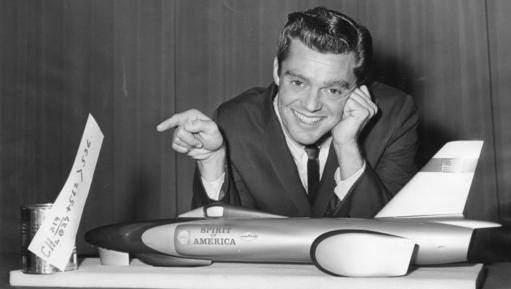 In this Oct. 28, 1964 photo, Craig Breedlove appears with a model of his jet-powered racer "Spirit of America" at the Water Tower Hotel in Chicago. A judge has ruled that Breedlove can move forward with his legal claim that Chicago's Museum of Science and Industry damaged the jet car he used to set a land-speed record at the Bonneville Salt Flats in Utah in 1964. Breedlove says the museum caused more than $395,000 in damage to the car. It was displayed at the museum for 50 years and returned to him in October 2015.