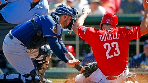 Cincinnati Reds left fielder Adam Duvall (23) scores a run ahead of the tag by Milwaukee Brewers catcher Manny Pina, left, during the fourth inning of a spring training baseball game, Sunday, March 12, 2017, in Goodyear, Ariz. (AP Photo/Ross D. Franklin)