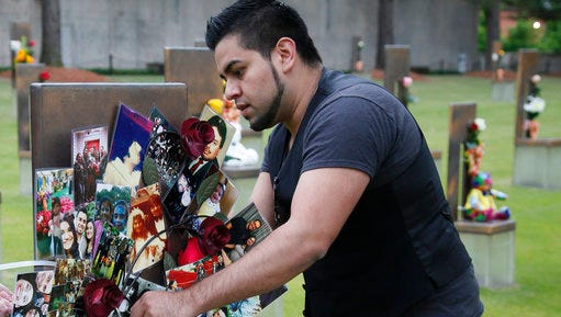Brian Martinez, 31, attaches a wreath made of family photos to his father's chair in the Field of Chairs at the Oklahoma City Memorial in Oklahoma City, Wednesday, April 19, 2017, the 22nd anniversary of the Oklahoma City bombing, which killed is father, Rev. Gilbert X. Martinez.Survivors and family members of those killed in the Oklahoma City bombing will gather for a remembrance service Wednesday, the 22nd anniversary of the attack. Carson is speaking at the 22nd Anniversary Remembrance Ceremony.