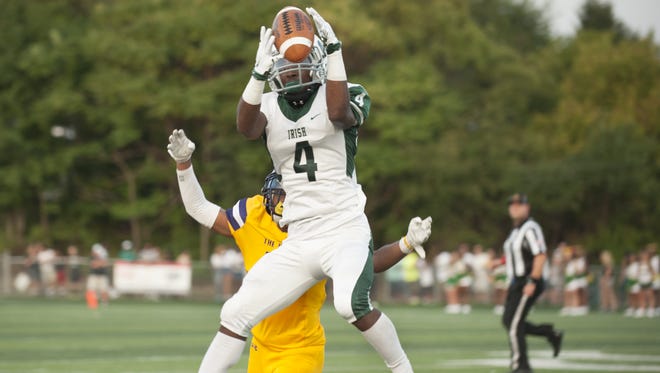 Camden Catholic's Kyle Dupree catches a pass in front of Camden's David Taplin during the first quarter of Friday's game.