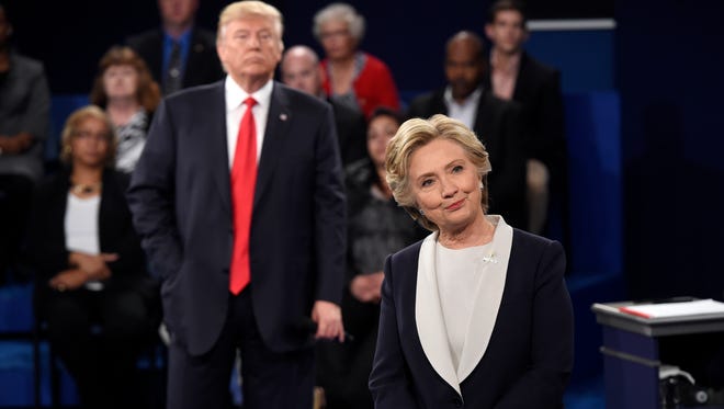 Democratic presidential nominee Hillary Clinton, right, and Republican presidential nominee Donald Trump listen to a question during the second presidential debate at Washington University in St. Louis, on Sunday, Oct. 9, 2016.
