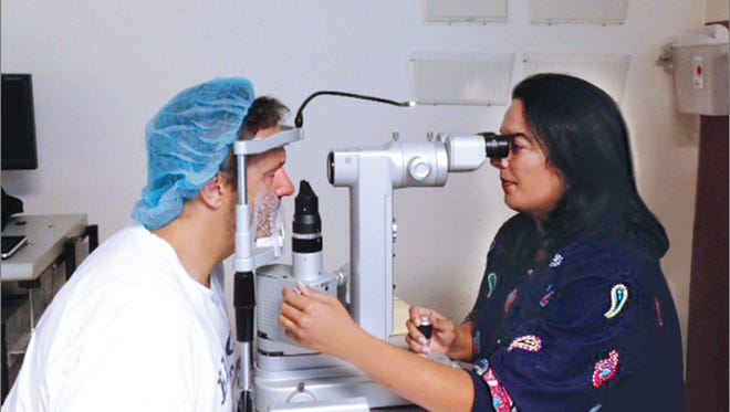 Dr. Rainna-Bahadur examines the eyes of Biloxi police investigator Nick-Sonnier, following his LASIK eye surgery to correct his nearsightedness.