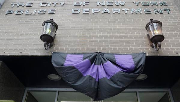 Bunting is draped from the front of the 84th Precinct in the Brooklyn borough of New York, Sunday, Dec. 21, 2014. Ismaaiyl Brinsley, who vowed online to shoot two "pigs" in retaliation for the police chokehold death of Eric Garner, ambushed two New York City officers in a patrol car Saturday and fatally shot them in broad daylight before running to a subway station and killing himself, authorities said. Officers Rafael Ramos and Wenjian Liu were stationed at the precinct. (AP Photo/Mark Lennihan)