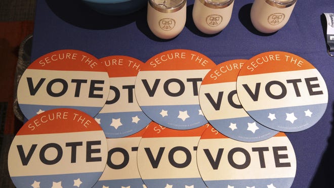 FILE - In this July 14, 2018, file photo, computer mouse pads with Secure the Vote logo on them are seen on a vendor's table at a convention of state secretaries of state in Philadelphia.