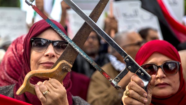 People demonstrate with saws Tuesday Nov. 27,...