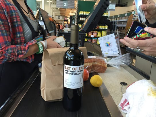 A customer buys a bottle of wine at the Turnip Truck