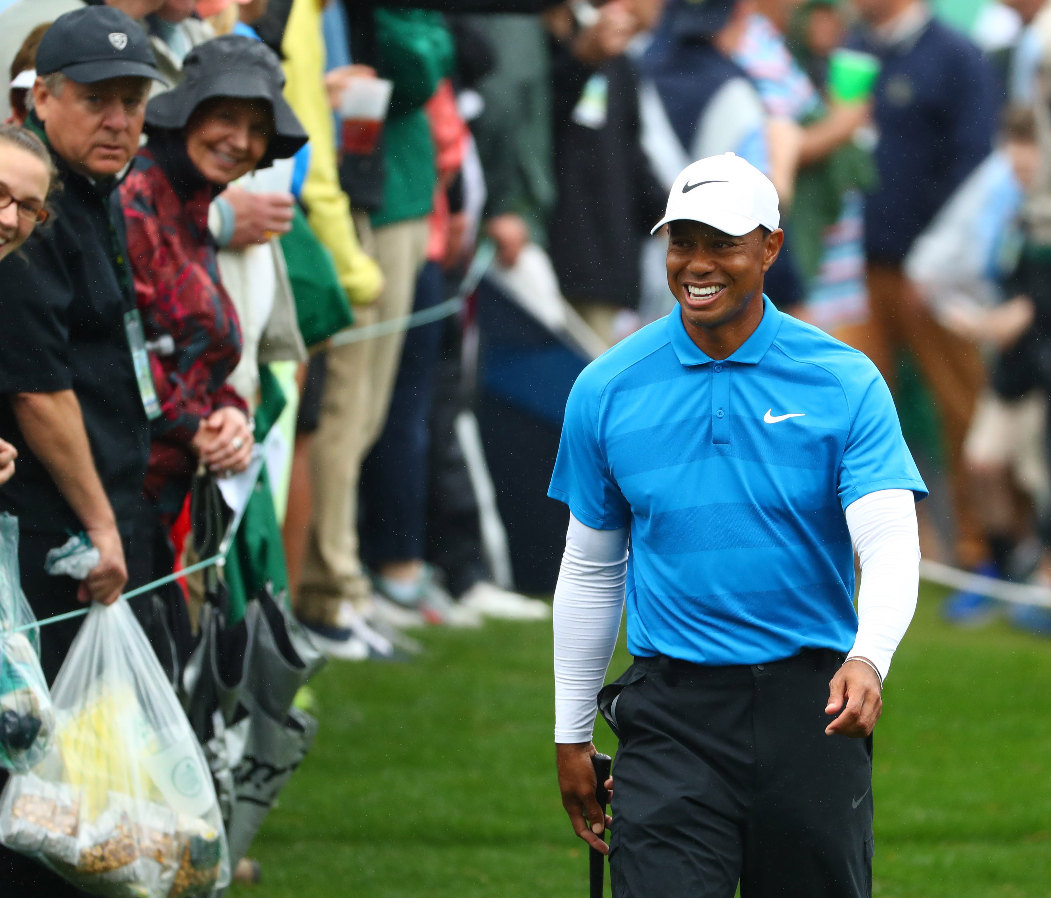 Tiger Woods smiles as he walks to the 8th tee during the third round of the Masters golf tournament at Augusta National Golf Club.