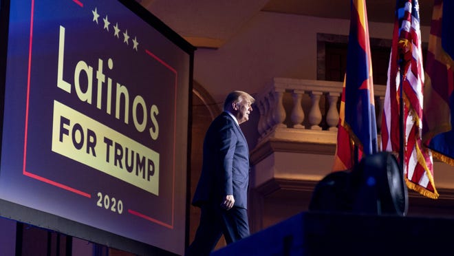 FILE - In this Sept. 14, 2020 file photo, President Donald Trump arrives for a Latinos for Trump Coalition roundtable at Arizona Grand Resort & Spa in Phoenix. President Donald Trump is putting up a fight for Latino voters in key swing states with Democratic candidate Joe Biden. Polls show Biden with a commanding overall lead with Hispanic voters, a diverse group that defies neat political categories. Still, about 3 in 10 registered Latino voters nationwide back Trump, roughly consistent with how Latinos voted in 2018 congressional elections and in 2016. Latino men, like men of other races, support Trump more than Hispanic women.