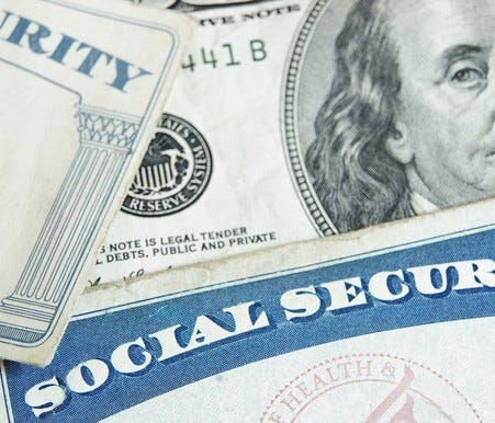 Two Social Security cards sitting on top of a $100 bill.