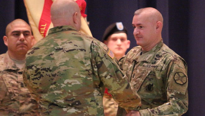 Command Sgt. Maj. Gabriel Espinosa, right, hands the guidon to garrison commander Col. Rob Salome on Tuesday during a change of responsibility ceremony at Fort Campbell's Wilson Theater. Command Sgt. Maj. Noel Foster (not pictured) will take over for Espinosa.