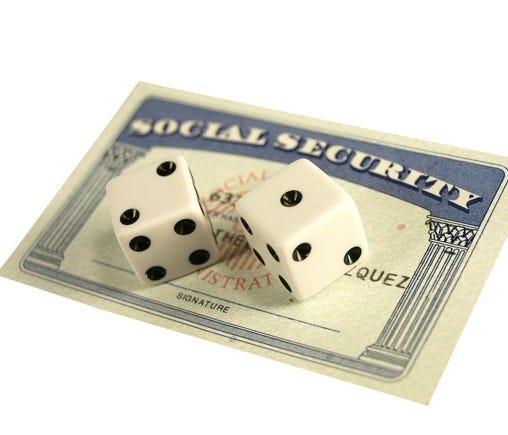 Social Security card with two dice on top of it.