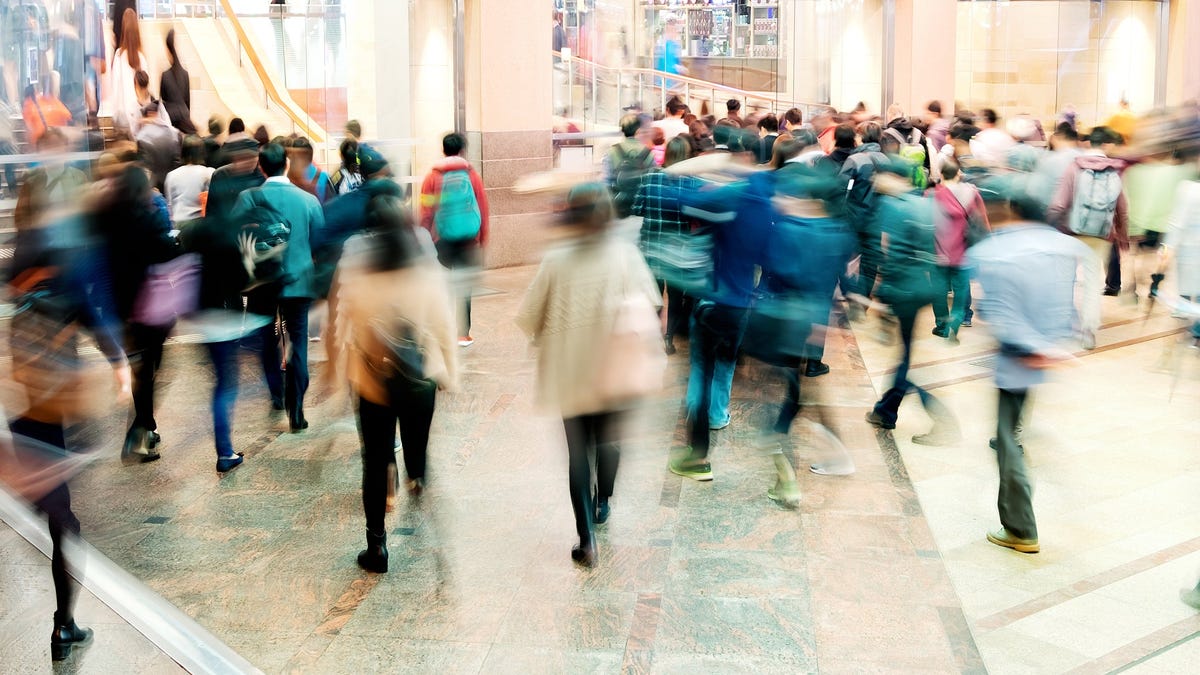 Blurry shoppers filing through a mall.
