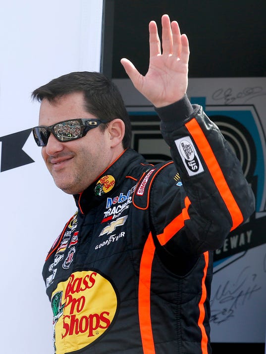 FILE - In this March 2, 2014, file photo, Tony Stewart waves to the crowd during driver introductions prior to a NASCAR Sprint Cup Series auto race in Avondale, Ariz. First went Jeff Gordon. Then Tony Stewart. Now Dale Earnhardt Jr. is packing his bags to leave NASCAR. All have their own reasons, but the nation's most popular auto racing series is a victim of its own popularity. (AP Photo/Ross D. Franklin, File)