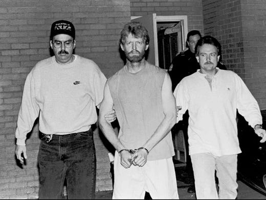 Daryl Holton, center, is led out of the Shelbyville