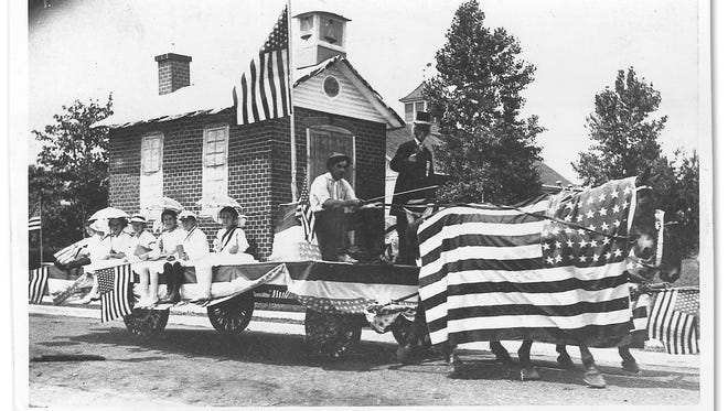 More then a century ago, in 1912, Ridgewood's Fourth of July parade featured this little red school house float pulled by flag-drapped horses. Driving the wagon is Jacob Van Syckle.