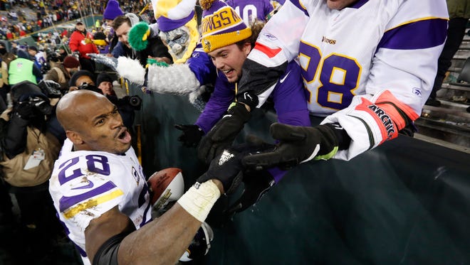 Minnesota Vikings' Adrian Peterson celebrates with fans after an NFL football game against the Green Bay Packers Sunday, Jan. 3, 2016, in Green Bay, Wis. The Vikings won 20-13. (AP Photo/Mike Roemer)