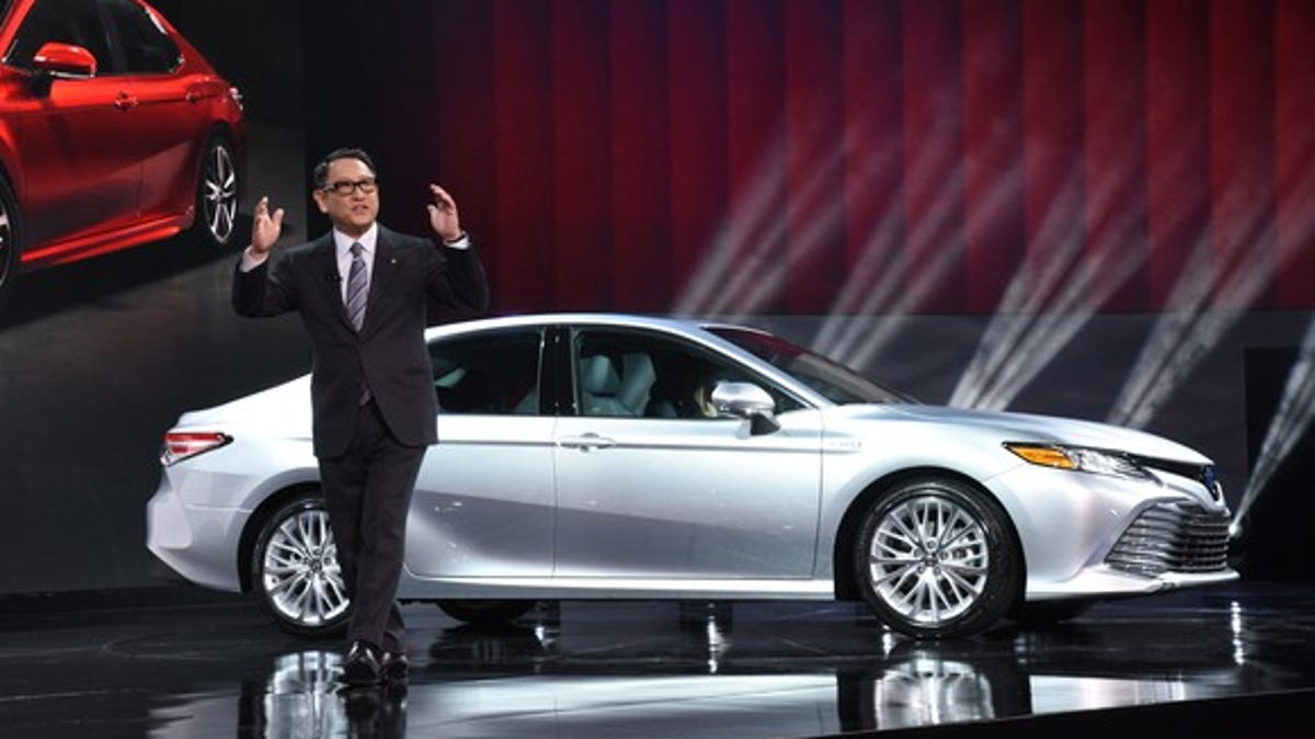 CEO Akio Toyoda, shown here in Detroit last year with Toyota's new-for-2018 Camry sedan, expects the weakening yen to lift Toyota to a record full-year profit.