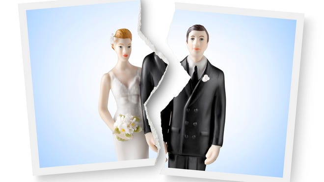 A photograph of a wedding cake topper is torn in half.